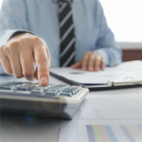 close up photo of man in suit using a calculator