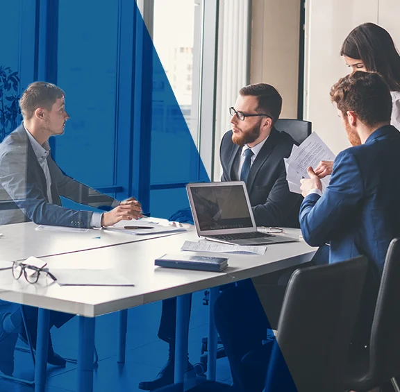 photo of 3 people having a business meeting around a table