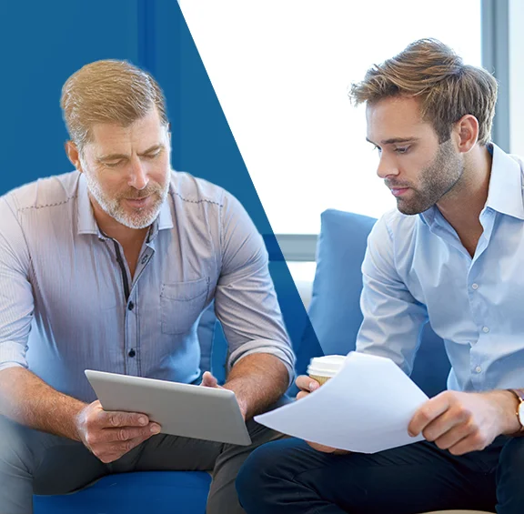 photo of two men sitting having a discussion over legal paperwork